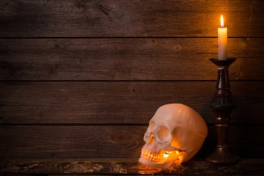 kafatası ve ahşap zemin üzerine mum