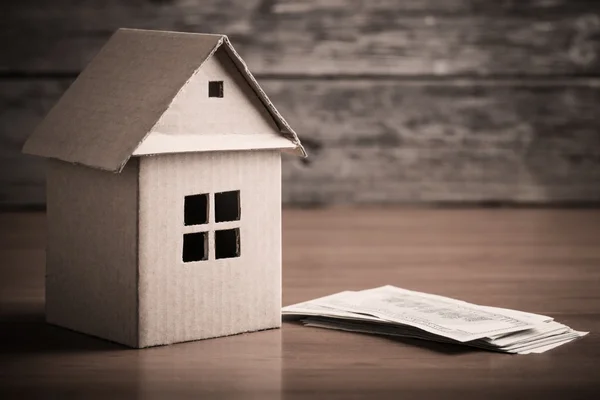 House from the paper and money on wooden background — Stock Photo, Image