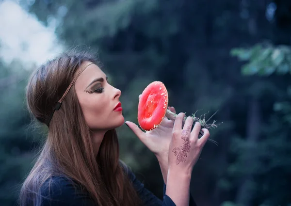 Hermosa bruja sosteniendo un hongo — Foto de Stock