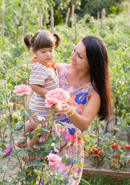 Glada kvinnor och små barn med rosor utomhus — Stockfoto