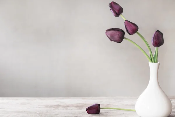 Tulipanes en jarrón blanco sobre mesa de madera — Foto de Stock