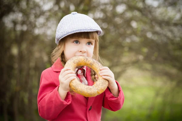 Rolig tjej med donut utomhus — Stockfoto