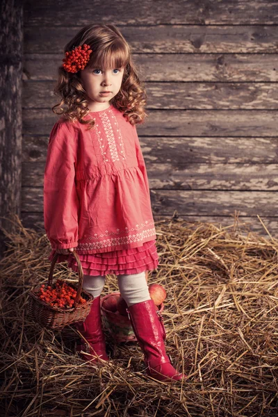 Kleines Mädchen in rosa Kleid auf Holzgrund — Stockfoto