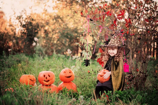 Klein meisje in halloween kostuum met jack pompoen — Stockfoto