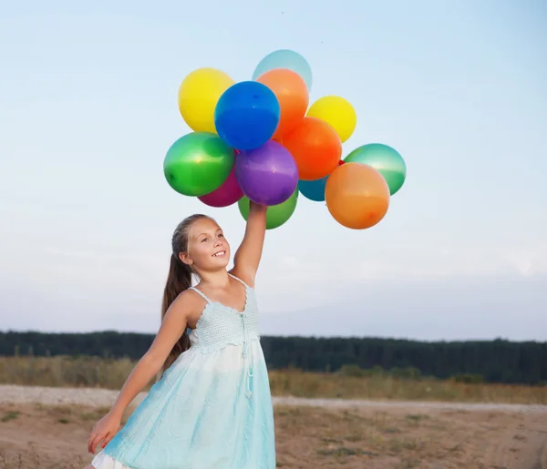 Щаслива дівчина з різнокольоровими кульками — стокове фото