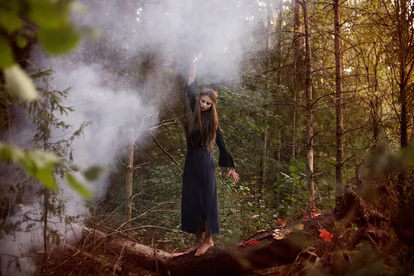 Young beautiful witch in autumn forest — Stock Photo, Image