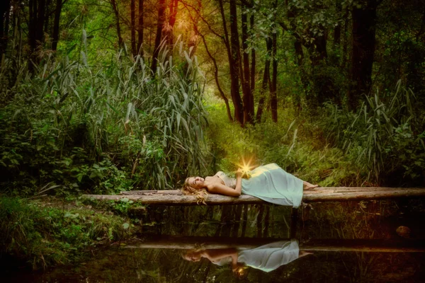 川と prac で木製の橋の上に座って美しい魔女 — ストック写真
