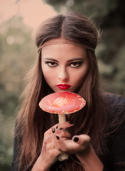Красивая ведьма держит гриб — стоковое фото