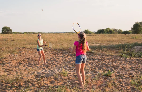 Две девушки играют в бадминтон на открытом воздухе — стоковое фото