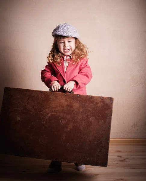 Little girl with suitcase indoor — Stock Photo, Image