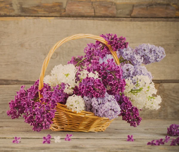 Корзина с лиловым цветком на деревянном фоне — стоковое фото