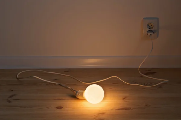 Lampje licht op houten vloer — Stockfoto