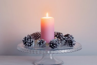 Çam kozalakları ile parlak yanan Noel mum 