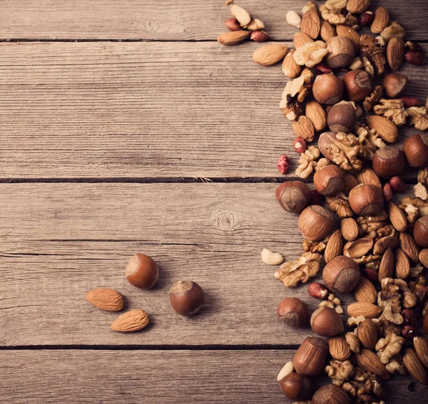 Nueces mixtas sobre fondo de madera viejo —  Fotos de Stock