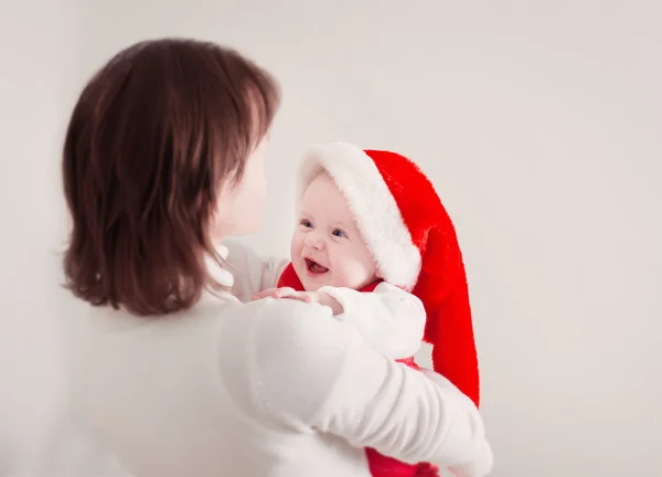 Mother and baby in red Christmas hat — Stock Photo, Image