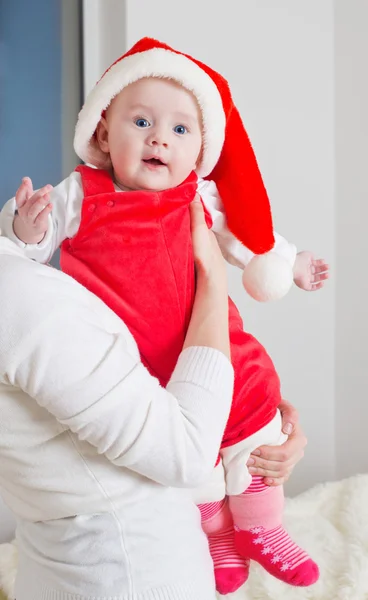 Moeder en baby in rode kerstmuts — Stockfoto