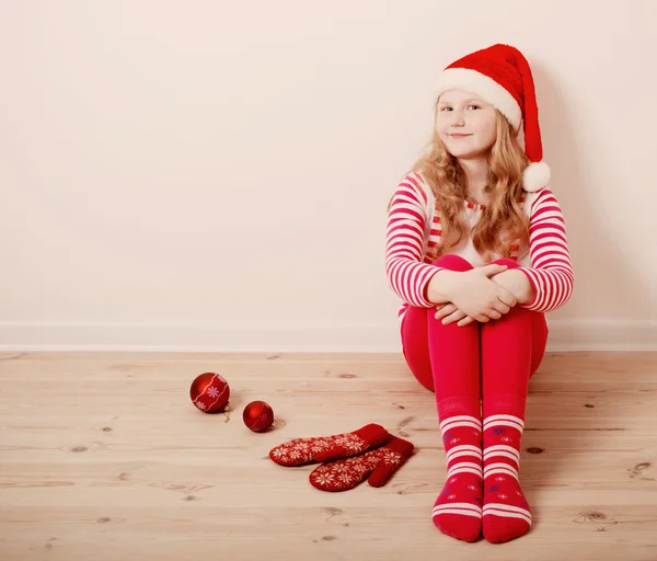 Menina feliz vestida de chapéu de Papai Noel — Fotografia de Stock