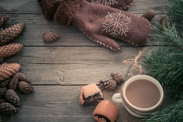 Kopje koffie, wanten en Kerstdecoratie op houten tafel — Stockfoto