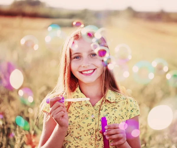 Счастливая девушка с мыльными пузырями — стоковое фото