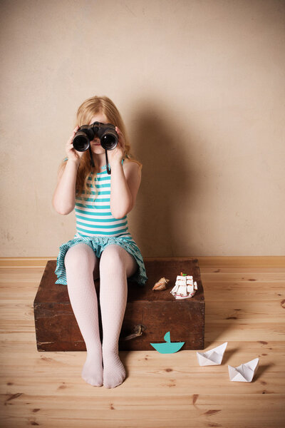happy girl playing with toy sailing boat indoors