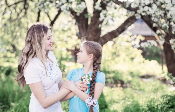 Happy mother with daughter in spring garden — Stock Photo, Image
