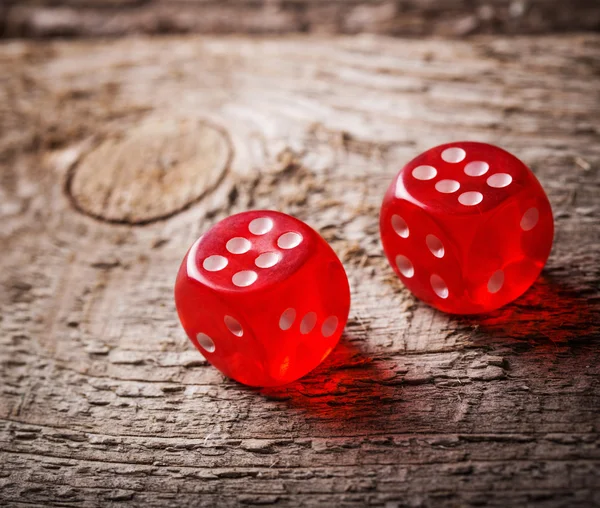 Pair of thrown red dices on old wooden table — Stock Photo, Image