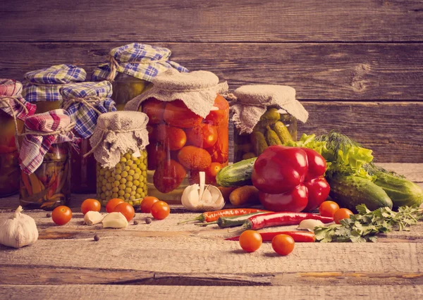 Bewaard en verse groenten op houten achtergrond — Stockfoto