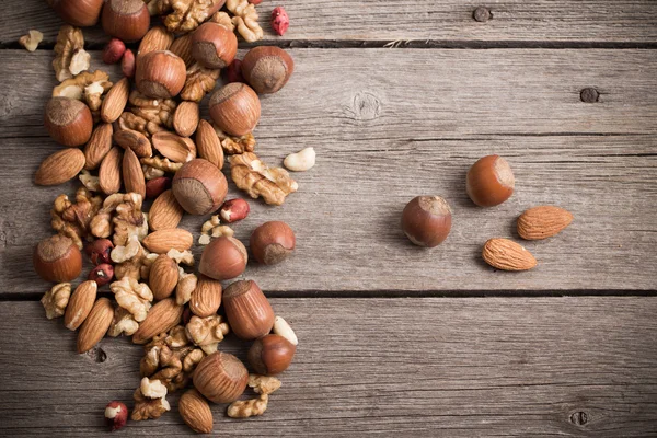 Nueces mixtas sobre fondo de madera viejo —  Fotos de Stock