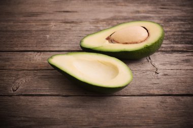 Ahşap arka plan üzerinde olgunlaşmış avokado