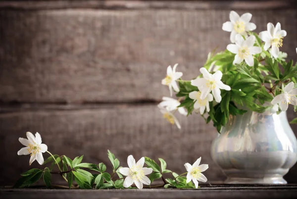 Snowdrops in vase on wooden background — Stock Photo, Image