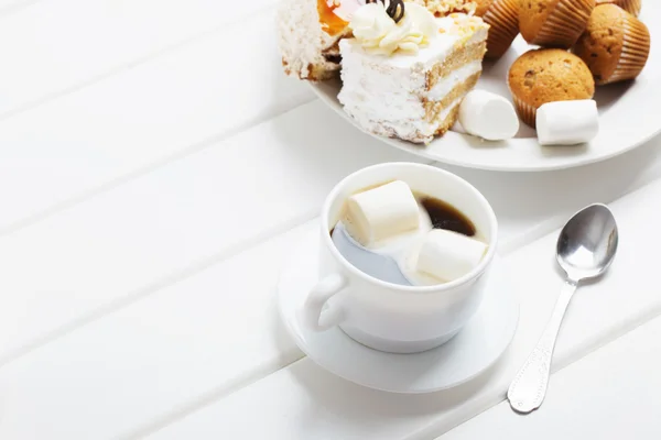 Café avec guimauve et gâteau sur fond de bois blanc — Photo