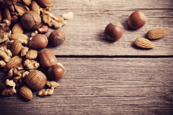 Smíšené ořechy na starém dřevěném pozadí — Stock fotografie
