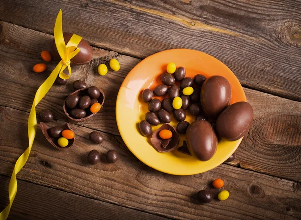 Ovos de Páscoa de chocolate sobre mesa de madeira — Fotografia de Stock