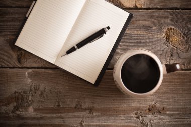 defter kalem ve eski ahşap masa kahve ile