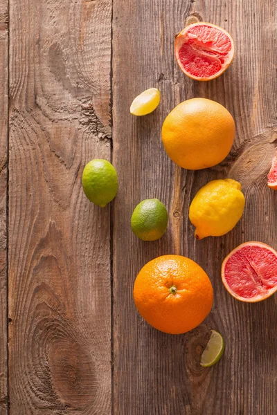 Set van gesneden citrusvruchten over houten achtergrond — Stockfoto