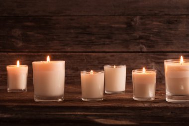 scented candles on old wooden background clipart