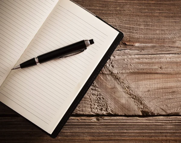 Cuaderno con pluma sobre mesa de madera vieja — Foto de Stock