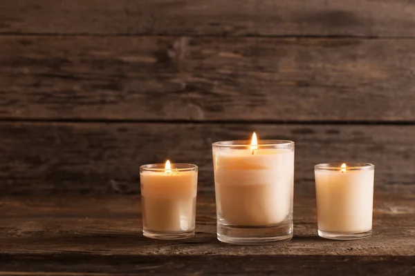 Scented candles on old wooden background — Stock Photo, Image