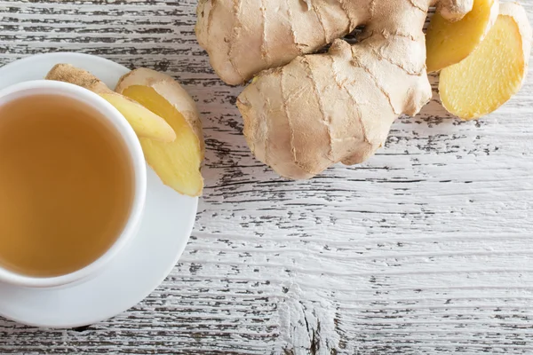 Thé au gingembre dans une tasse blanche sur fond bois — Photo