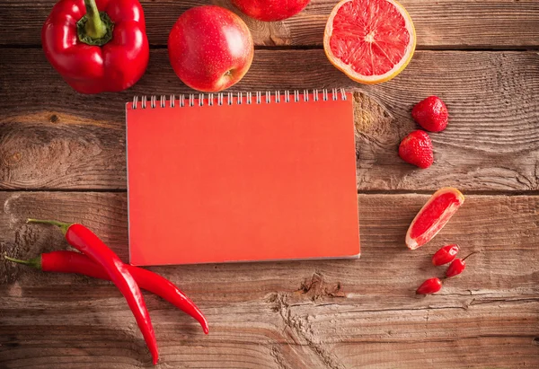 Red fruits and vegetables on wooden background