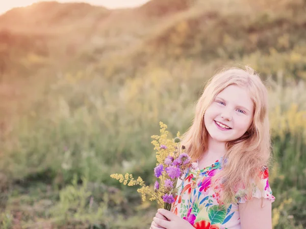 Menina loira feliz no prado ao pôr do sol — Fotografia de Stock