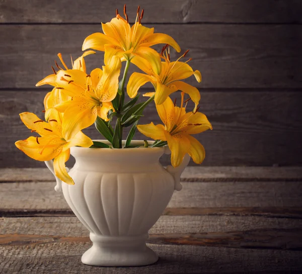 Lily in vase on wooden background — Stock Photo, Image