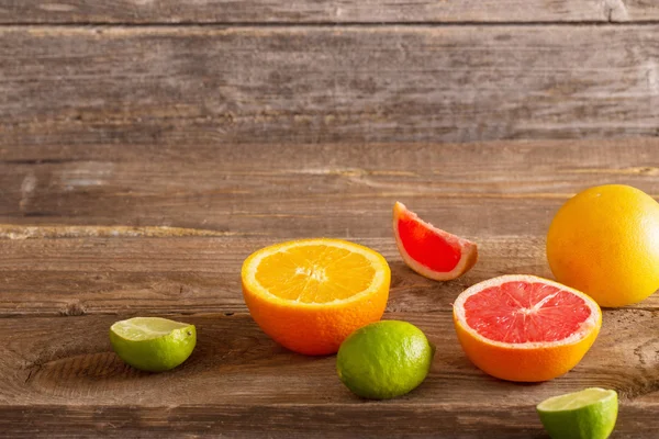 Gesneden citrusvruchten over houten achtergrond — Stockfoto