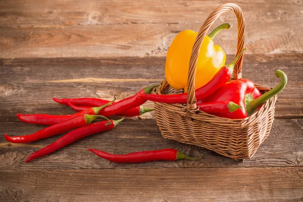 Pimientos en canasta sobre mesa de madera vieja — Foto de Stock