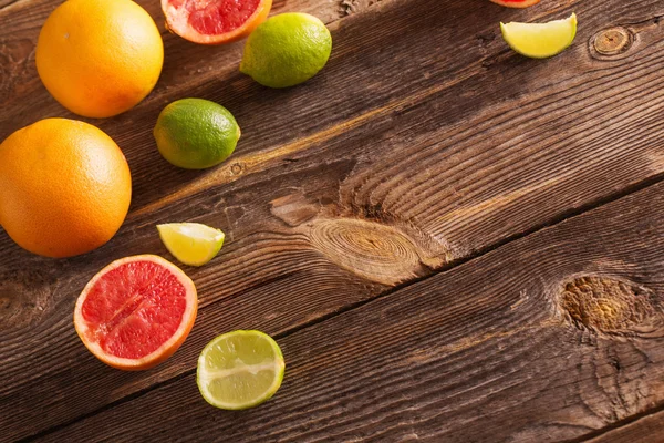 Set van gesneden citrusvruchten over houten achtergrond — Stockfoto