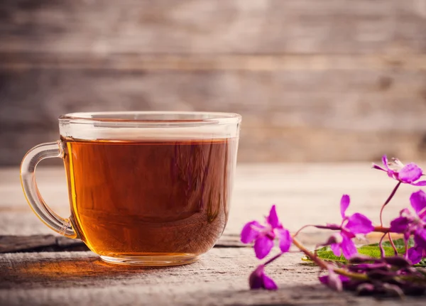 Cup of tea with willow-herb on wooden background — Stock Photo, Image