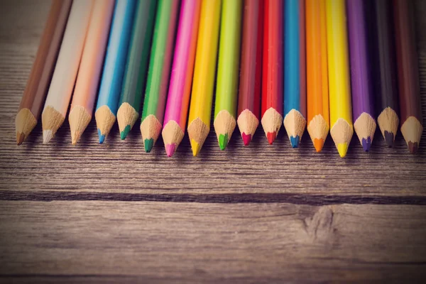 Multicolored pencils on the wooden background — Stock Photo, Image