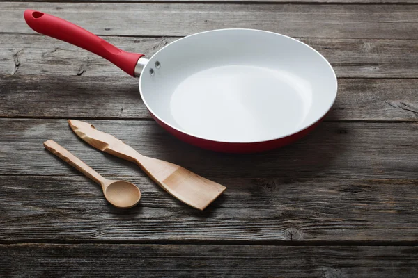 Frying pan on old wooden background — Stock Photo, Image