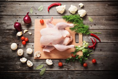 Tahta bir masada çiğ tavuk. 