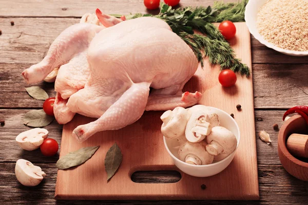 Whole raw chicken on a wooden table Stock Photo by ©Kruchenkova 69761551